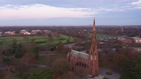 an aerial shot of a beautiful cathedral with a tall steeple during sunrise