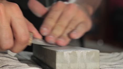 afilando un cuchillo escandi desafilado con una piedra de afilar