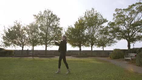 mujer caminando por un parque hablando por videollamada en su teléfono