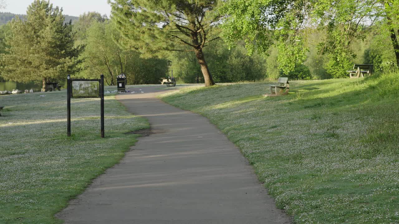 벤치와 넘치는 쓰레기통으로 공원을 가로질러 이동하는 시점