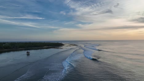 drone shot of perfect waves rolling down the point of g-land indonesia at sunset