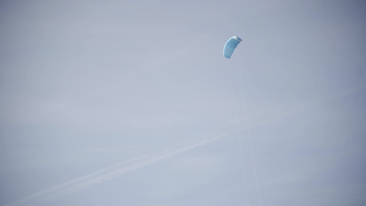 Blue kite flying around in front of blue sky at the north sea, Germany 4K