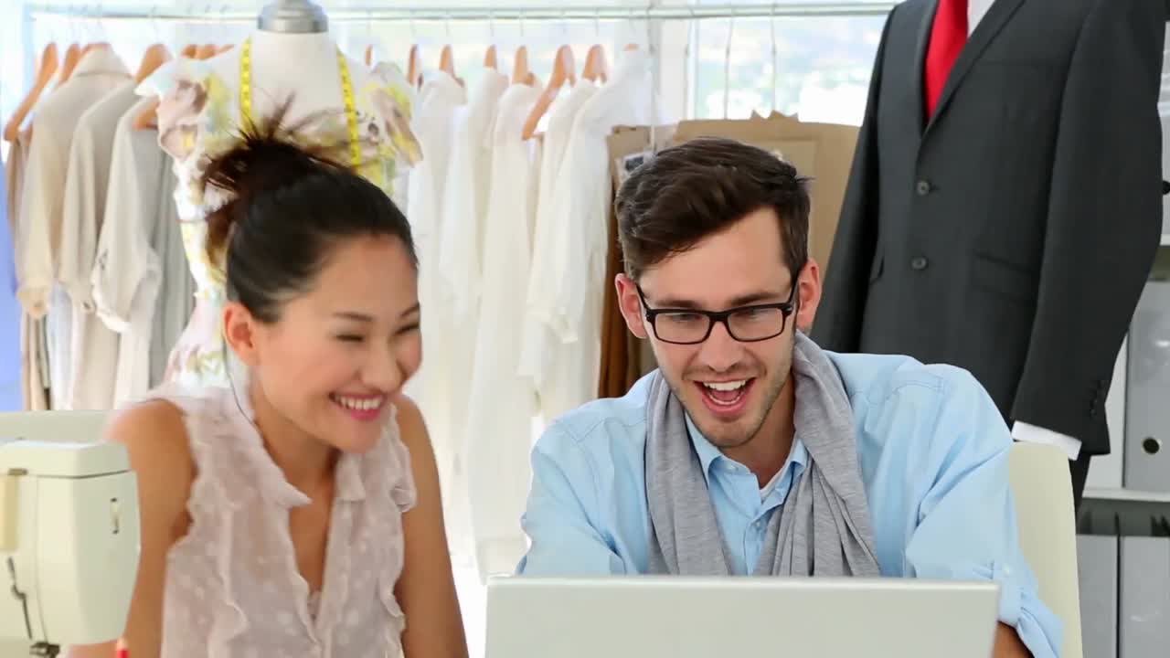 패션 디자인 팀이 노트북에서 함께 일하고 있습니다.