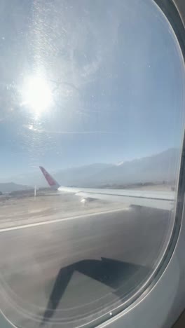 airplane wing on the plane window above the himalayas mountains