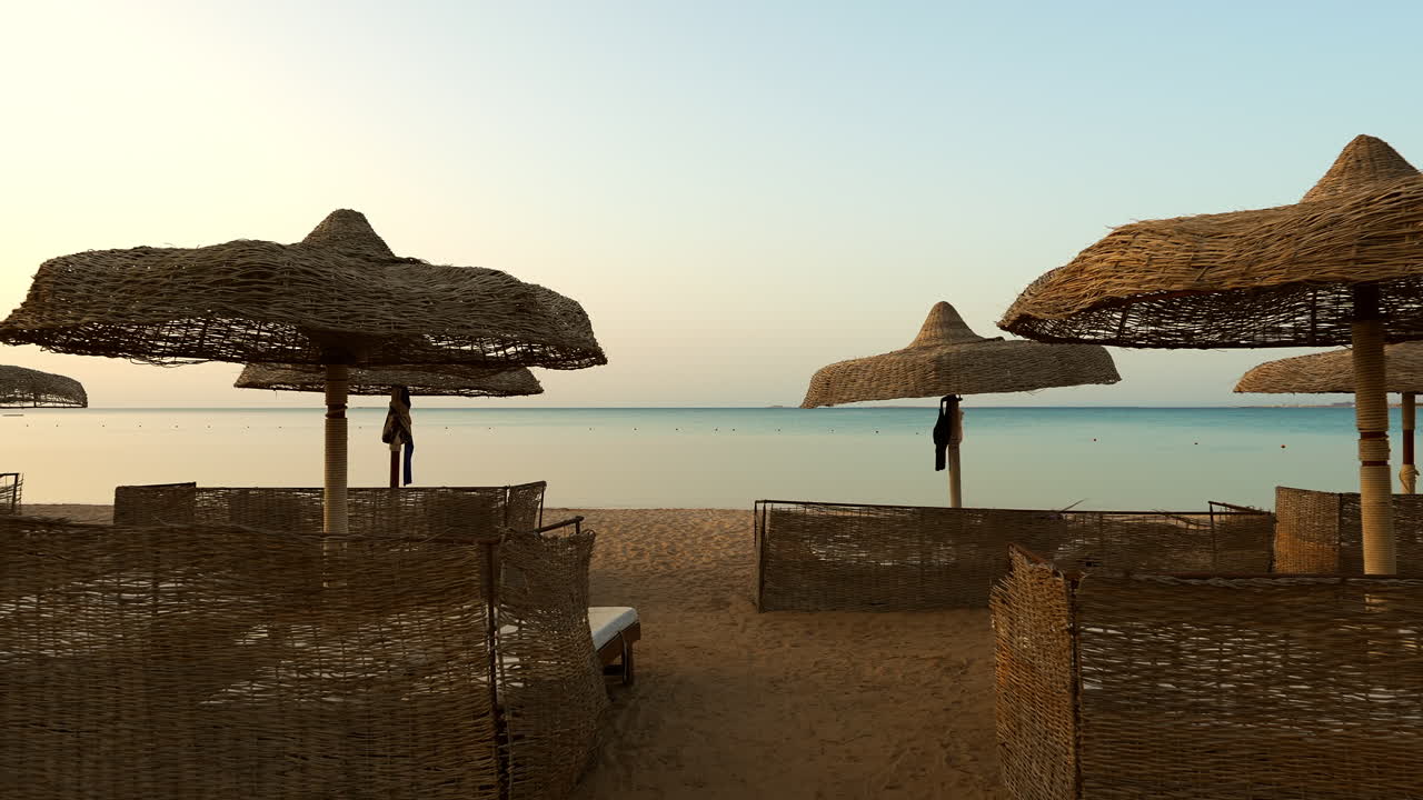 Luxusní písečná pláž s plážovými lehátky a slunečníky v tropickém letovisku na pobřeží Rudého moře, Egypt, Afrika