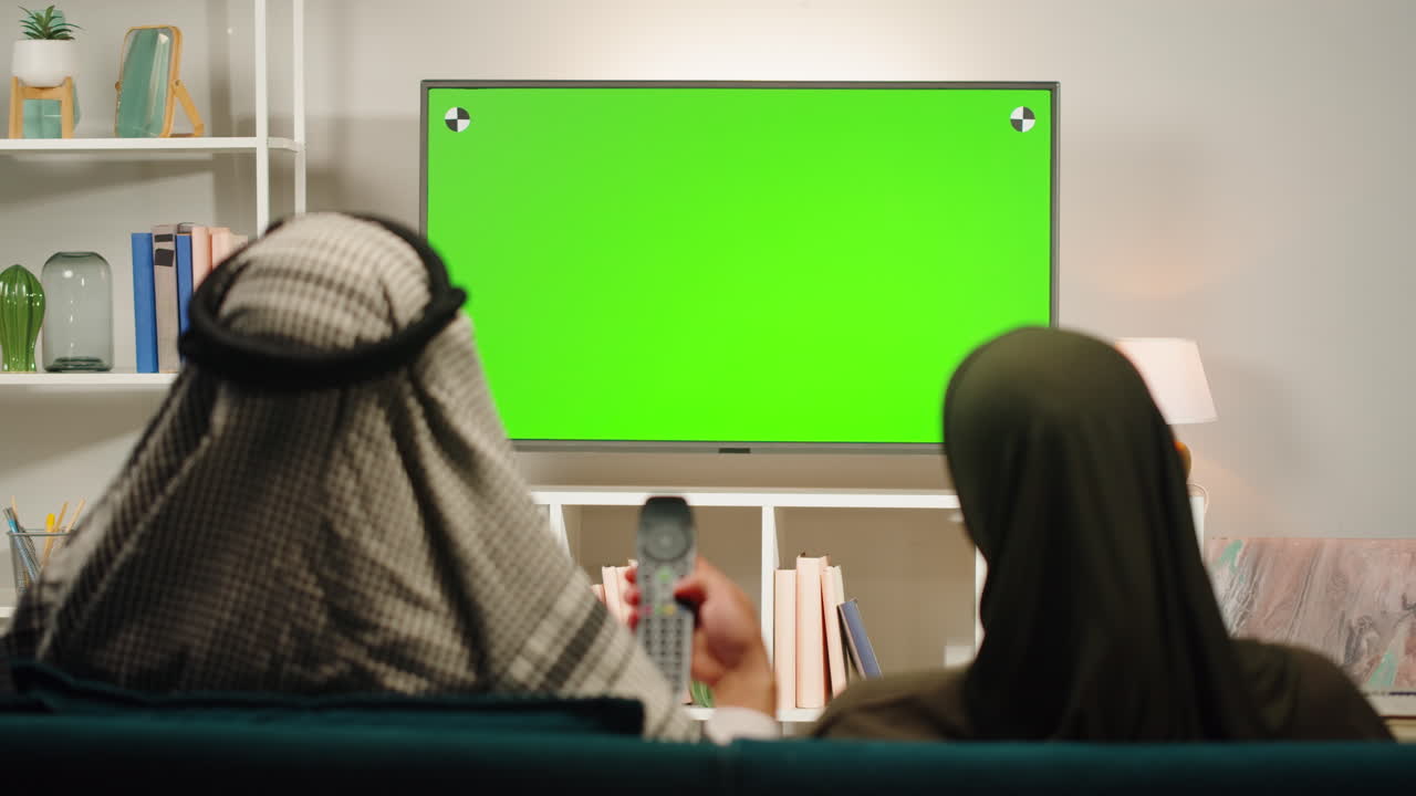 Couple Watching Green Screen TV at Home