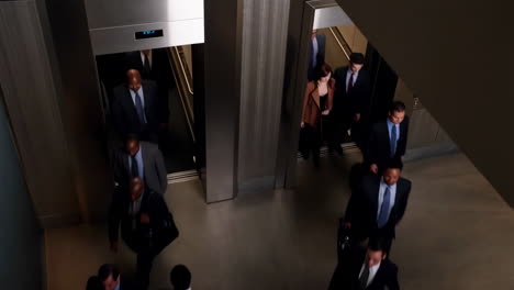 business professionals in a modern building lobby with elevators