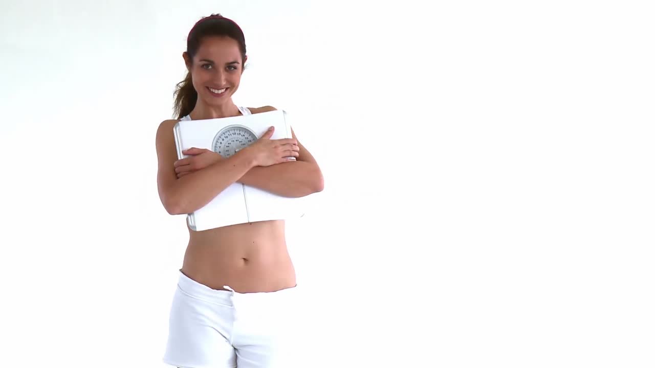 Donna ispanica sorridente con una bilancia