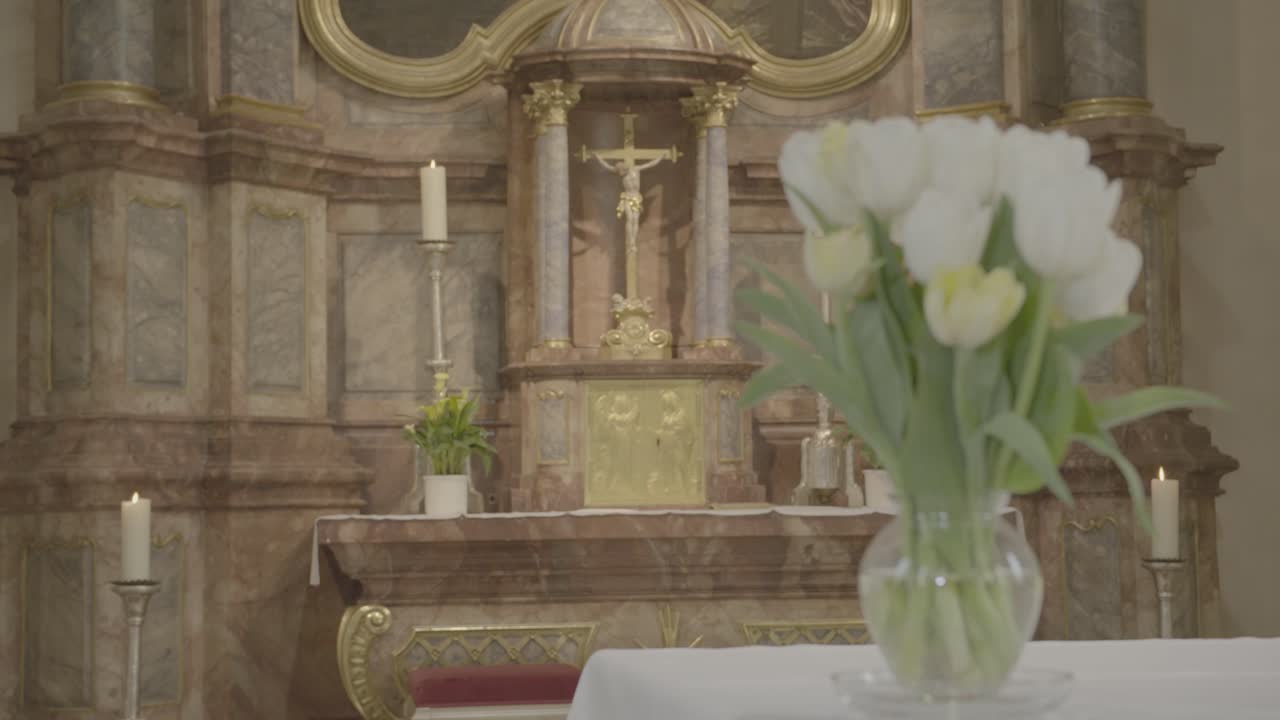jarrón de flores con tulipanes blancos en un altar frente a un presbiterio barroco