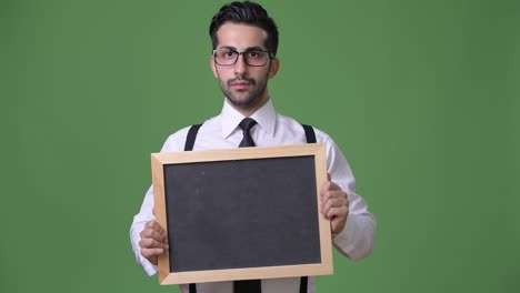 young handsome bearded persian businessman against green background