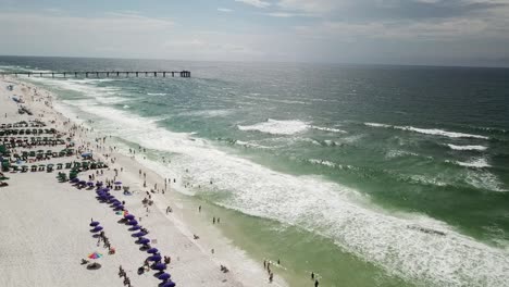 tourists enjoying at fort walton beach with a view of okaloosa island fishing pier in florida, usa