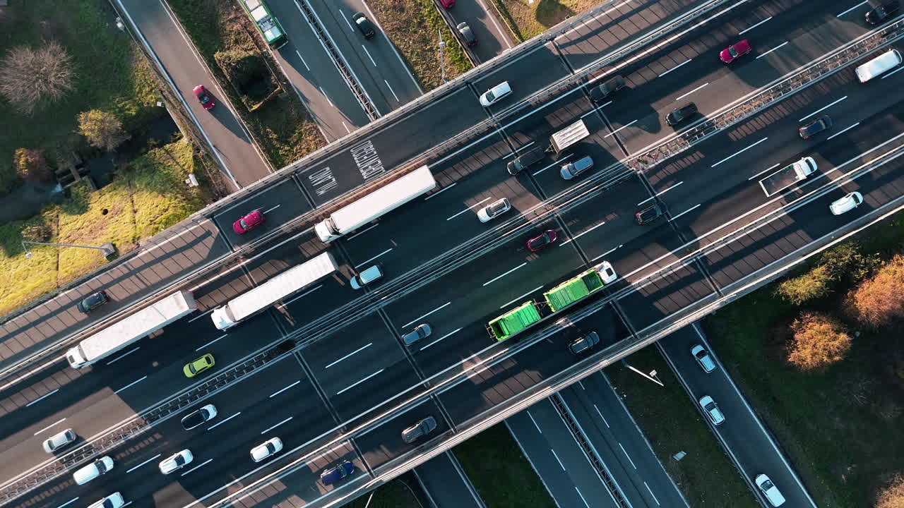 Aerial view of busy highway intersection on a sunny day, showcasing urban life