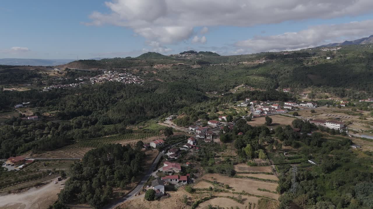 Drone aerial over Vila Real Portugal showing hillside village, farmland, and forest landscape