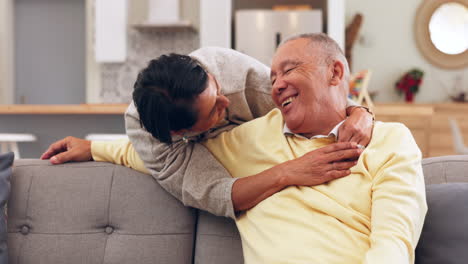 Senior-couple-hugging-on-a-sofa-laughing-together