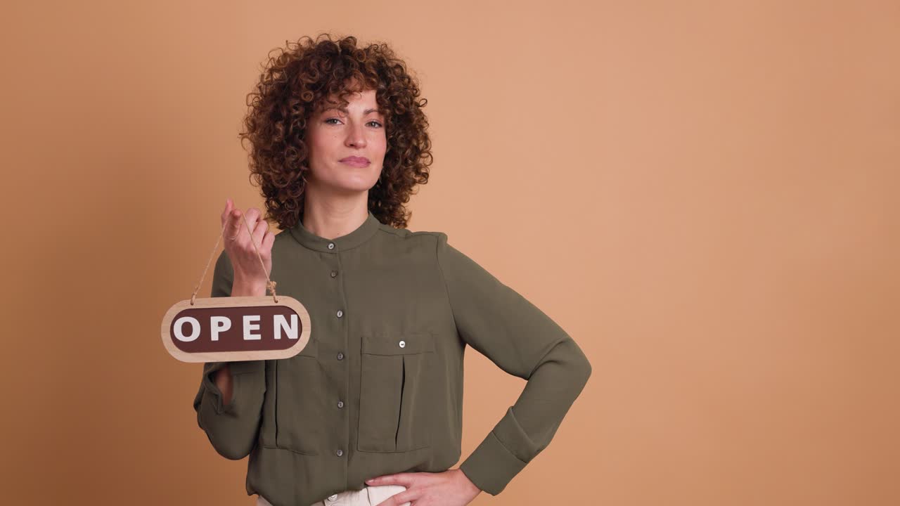 woman with open sign on a beige background