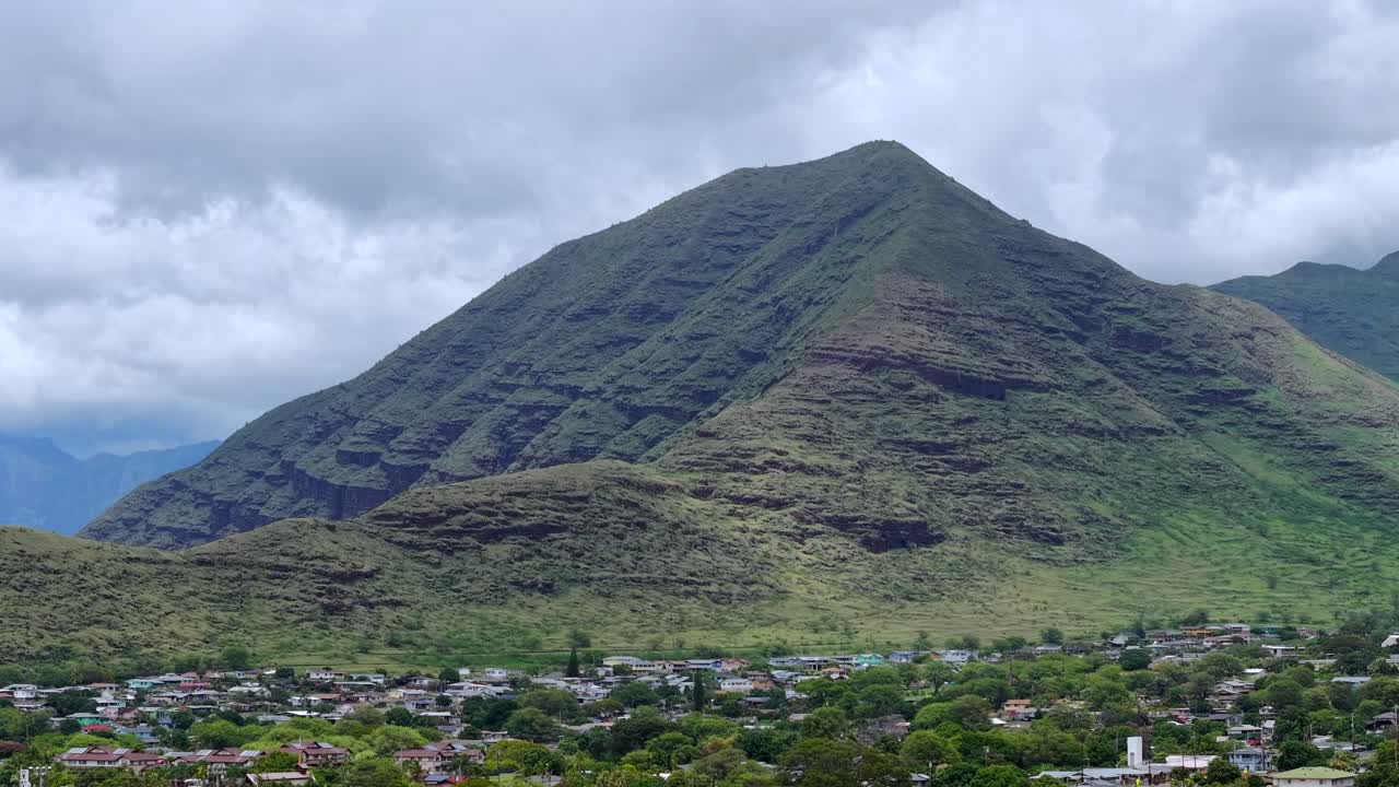 Large ridged green mountain looms over a residential community in Waianae