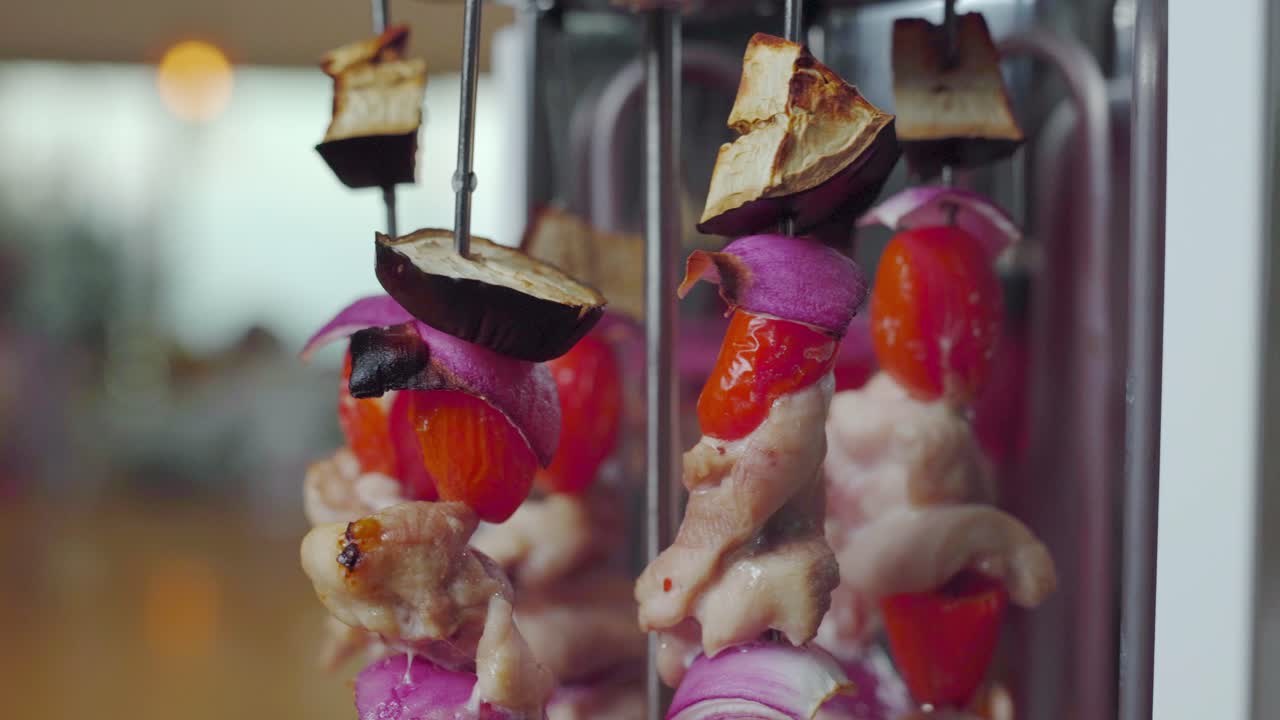 Chicken and vegetable Shish kabob skewers rotating while cooking on electric grill