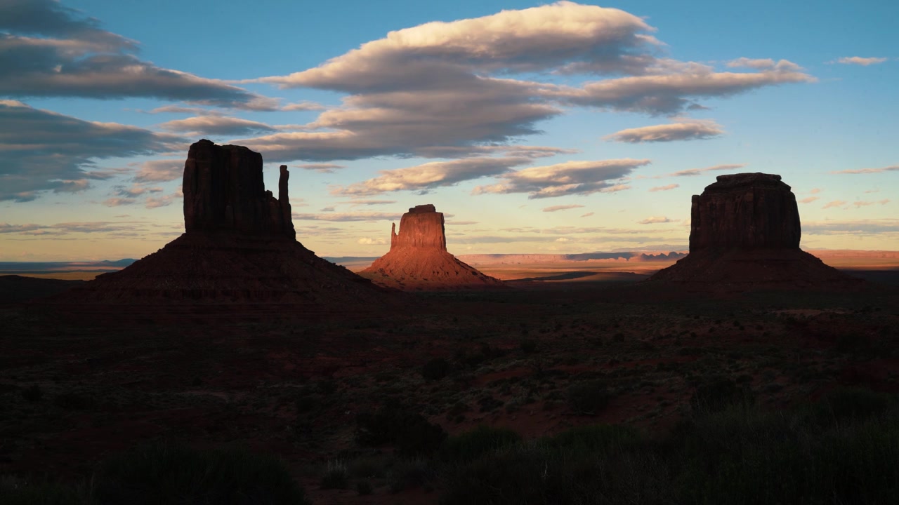 Los buttes de Monument Valley, conocidos como The Mittens, bajo dramáticos contrastes de luz y sombra cerca del atardecer