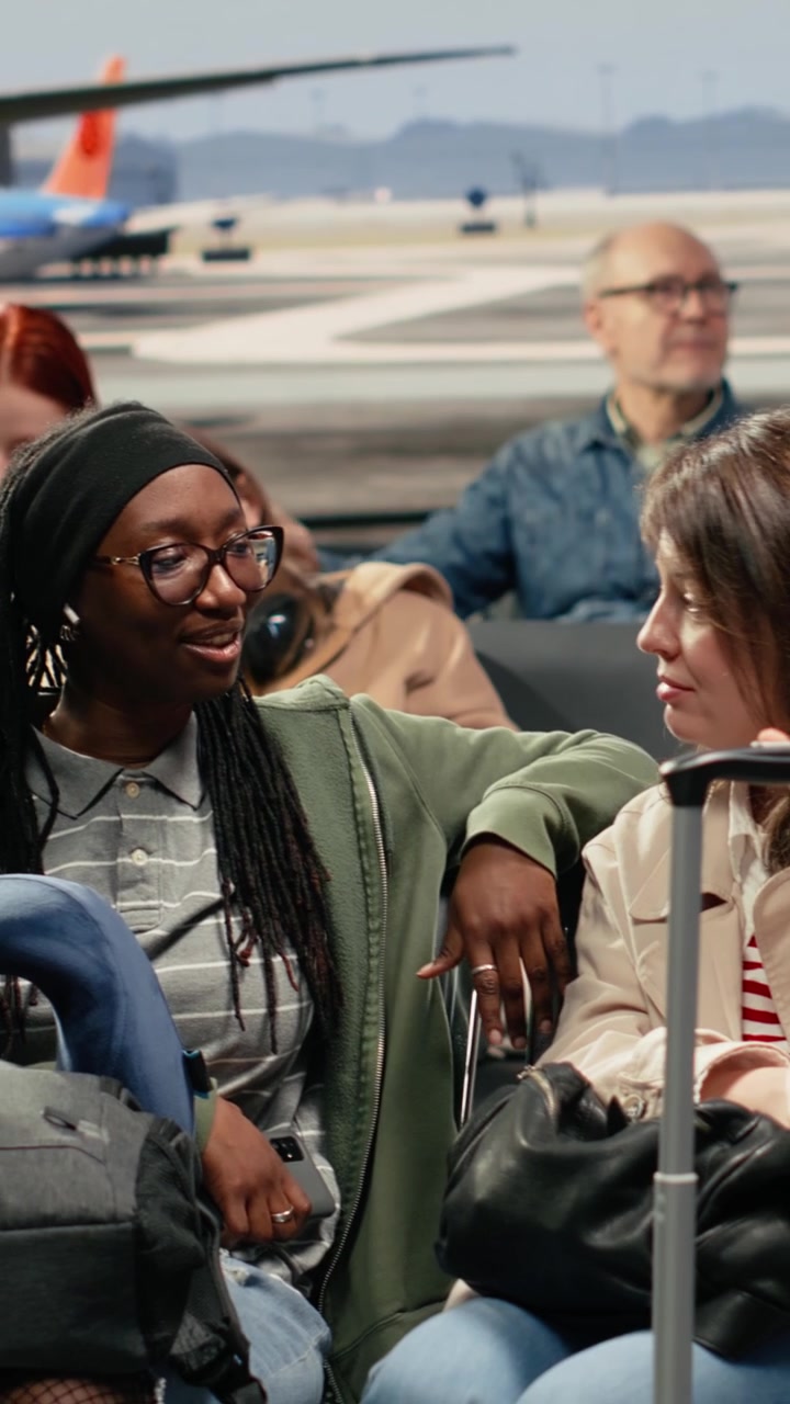 Vertical video Smiling women in airport travelling to explore foreign country