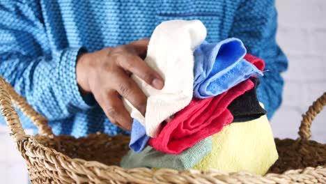 young man putting clothes in basket