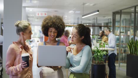 Diverse-female-business-colleagues-talking-and-using-laptop