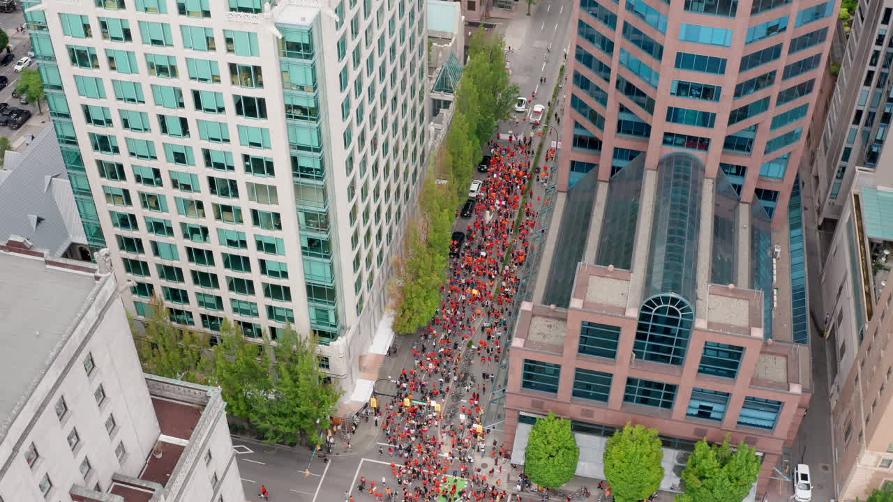 manifestantes marchando en las calles del centro de vancouver, vista aérea en órbita