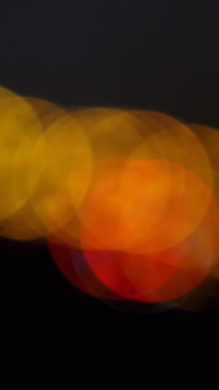 Animation von orangen Spotlichtern über schwarzem Hintergrund mit Platz für Text.