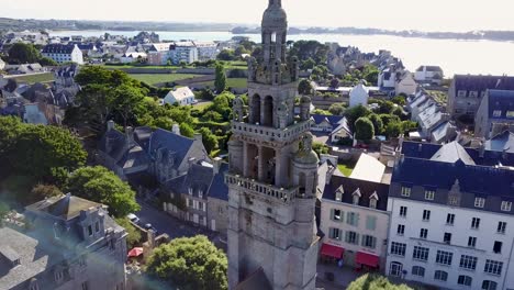 Rückwärtsfliegen-Mit-Blick-Auf-Den-Glockenturm-Einer-Kirche,-Mit-Dem-Meer-Im-Hintergrund