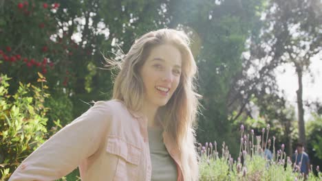 portrait of happy caucasian woman in garden on sunny day