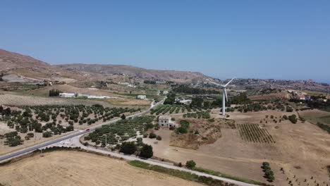 aerial: traditional italian farm with modern wind turbine, sustainability