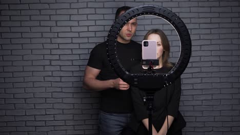 shooting of blogger couple with ring led lamp on brick wall background