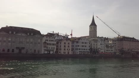 Famosa-Iglesia-Fraumunster-Y-Puente-Munsterbrucke-Sobre-El-Río-Limmat-Durante-La-Hora-Azul-De-La-Tarde-En-El-Casco-Antiguo-De-Zurich,-La-Ciudad-Más-Grande-De-Suiza