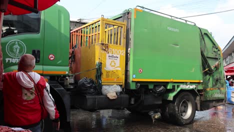 workers loading trash into a garbage truck