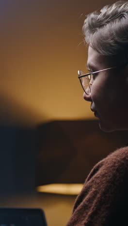 woman coding late night in a dark studio