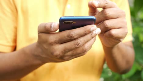 Young-men-in-yellow-shirt-using-smart-phone-,