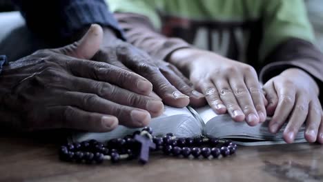 rezando a dios con la mano en el fondo negro de la biblia con personas material de archivo-4