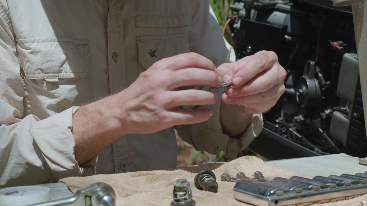 Boat outboard motor maintenance by an Australian Caucasian male. Outdoors, daytime, clip 21