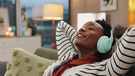woman relaxing at home listening to music with headphones