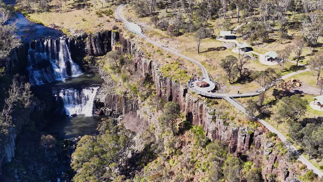 Aerial view of waterfall, lookout platform, and hiking trail