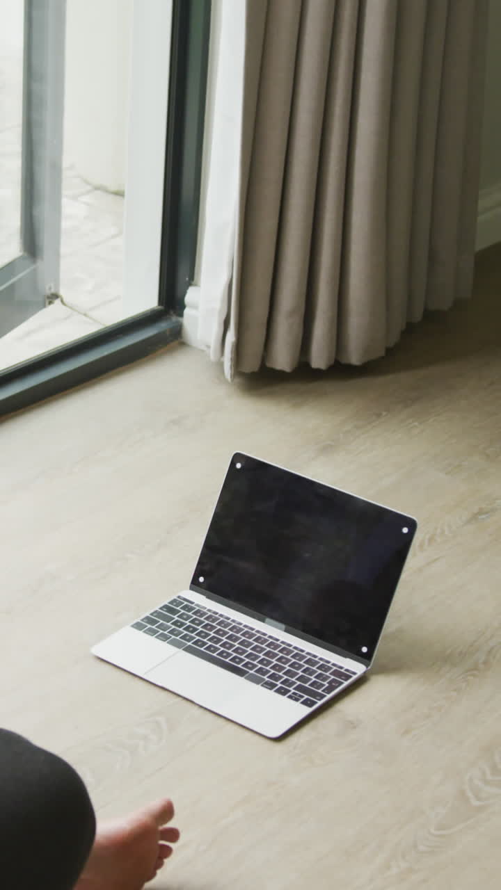 Video di donna afroamericana formosa che pratica yoga con un laptop e spazio per il testo.