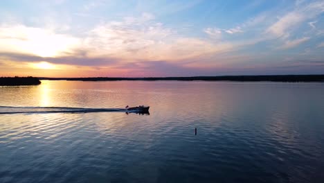 christ craft boat going across screen during sunset