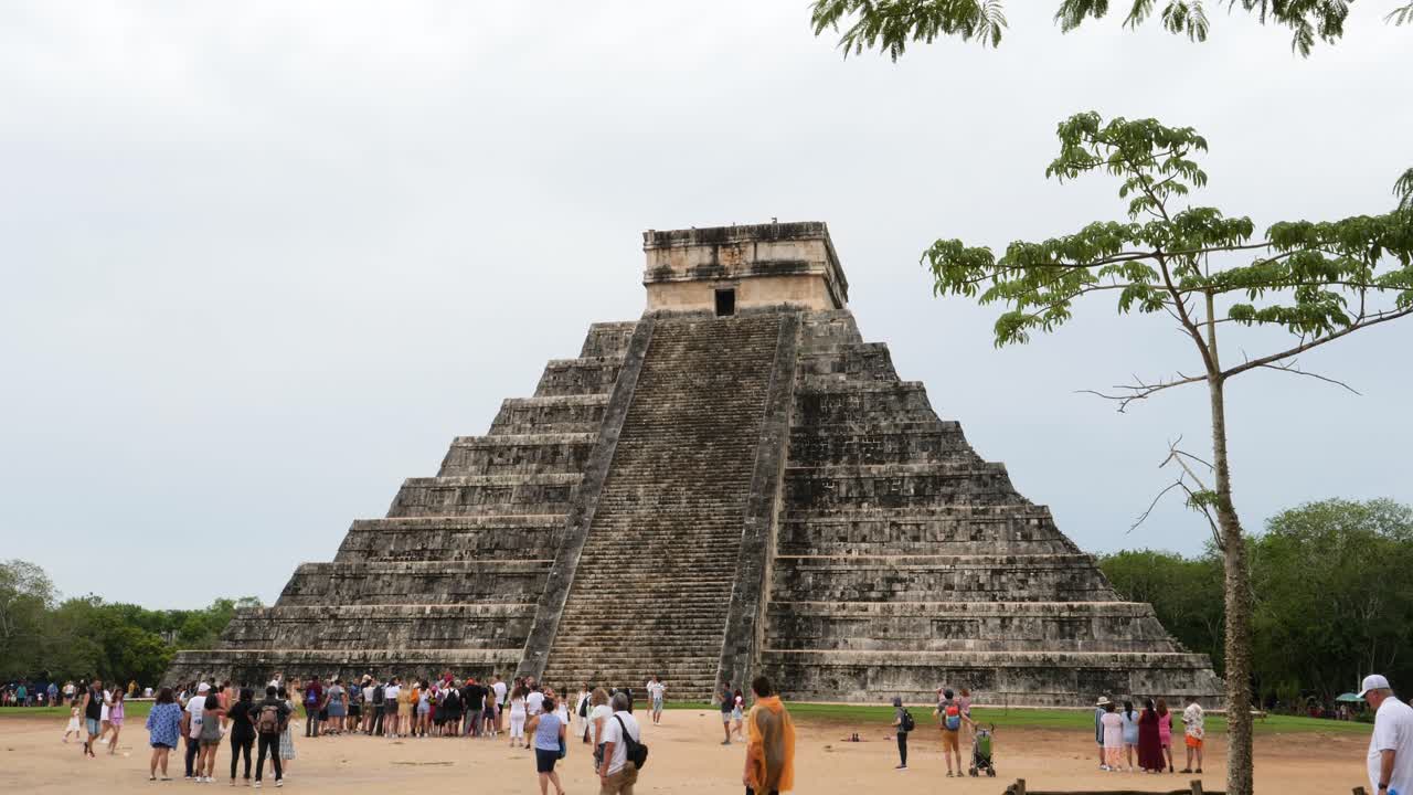 Tourists visiting El Castillo (Temple of Kukulcan), dominates the center of the Chichen Itza archaeological site.