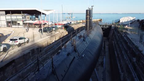 drone shot flying over a docked submarine.