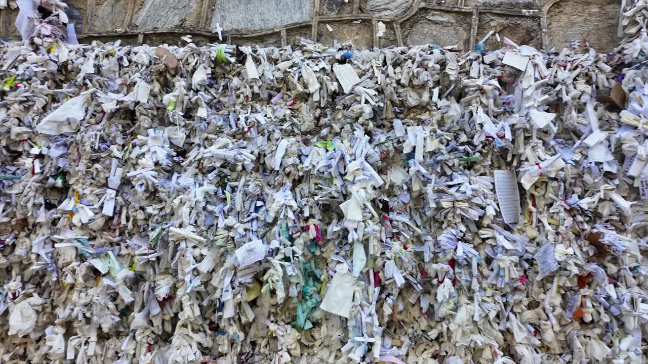 handwritten prayers stuffed into cracks in the wall near the Virgin Mary's home in Mt. Koressos, Turkey