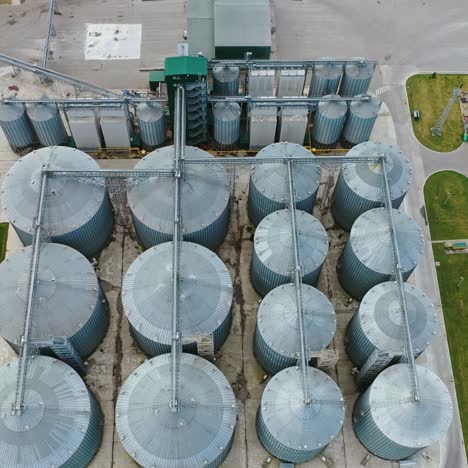 granaries for agriculture harvest. steel grain elevators in the field. agribusiness concept. aerial view.
