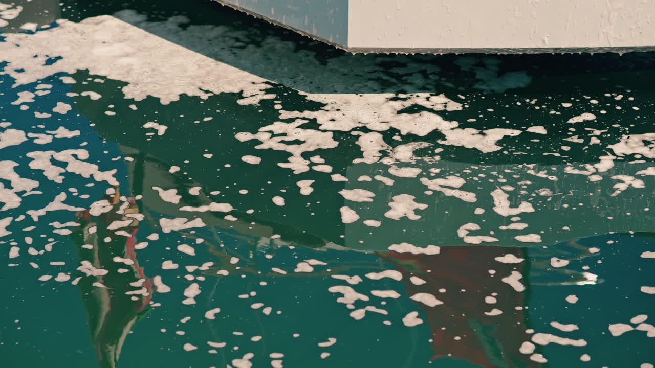 Close up of foam dripping into the blue sea from a platform