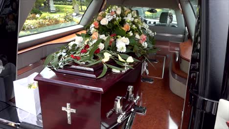 closeup shot of a funeral casket in a hearse or chapel or burial at cemetery