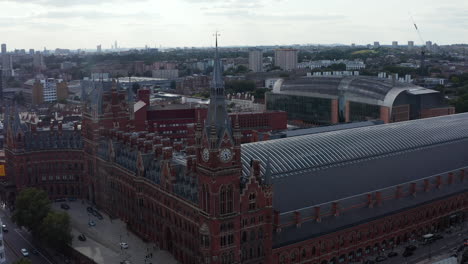 Amazing-aerial-footage-of-historic-front-brick-building-of-St-Pancras-international.--View-against-bright-clouds-in-sky.-London,-UK