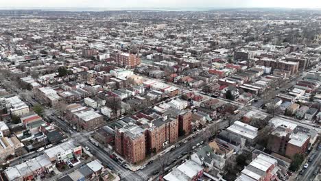 horizontal drone fly-around shot over troy ave, brooklyn, capturing new york’s dynamic cityscape, vibrant rooftops, and urban charm with a smooth aerial perspective.