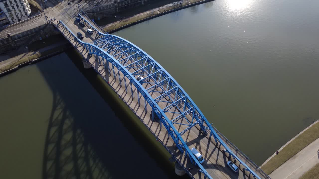 Aerial View of Blue Arched Bridge with Cars Crossing a River